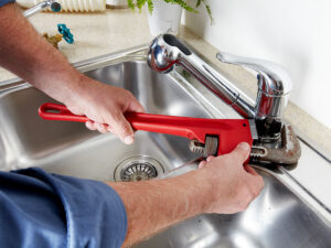 Plumber working on a kitchen sink.