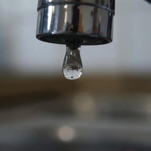 A crisp close-up of a faucet with a single water droplet at its tip, highlighting Divine’s attention to detail and quality service.